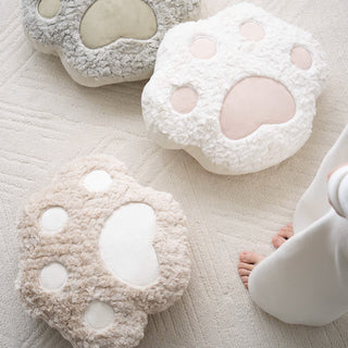 Coussin réconfortant à motif de pattes de chien dans des tons neutres, design doux et ludique